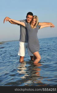 happy young couple have romantic time on beach at sunset