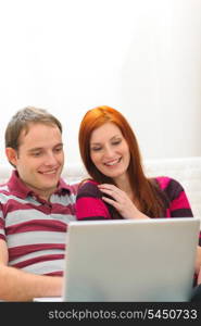 Happy young couple having fun time with laptop