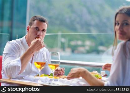 happy young couple having lanch at beautiful restaurant on by the sea on beach