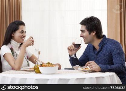 Happy young couple having wine at restaurant