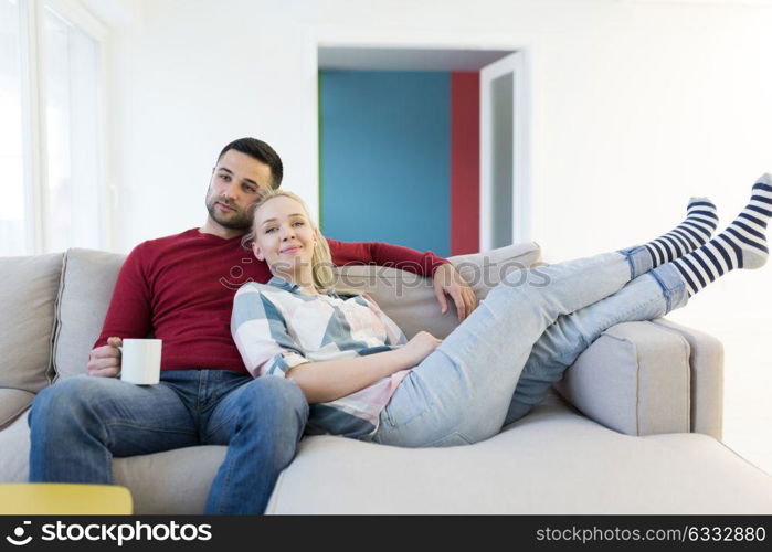 Happy young couple hugging and relaxing on sofa at home