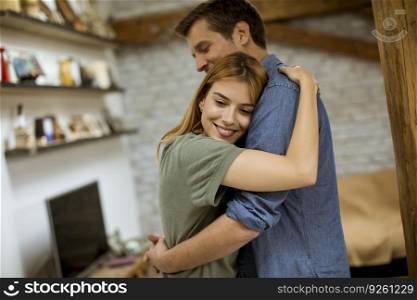 Happy young couple hugging in the loft apartment