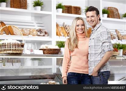 Happy young couple in a baker?s shop
