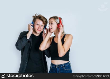 happy young couple in headphones listening music in studio