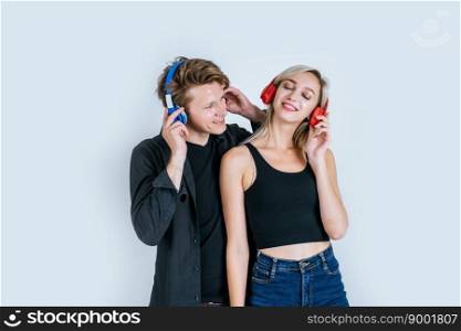 happy young couple in headphones listening music in studio