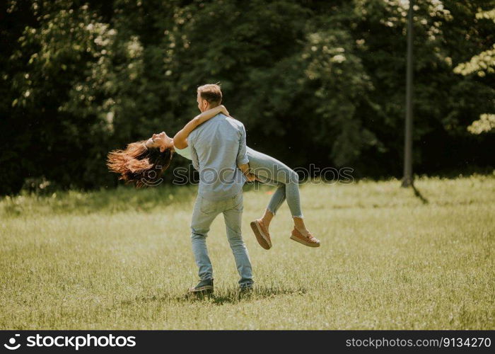 Happy young couple in love at the grass field on a summer day