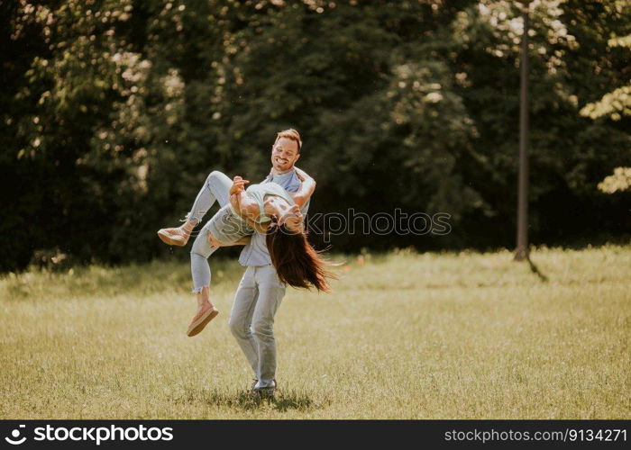 Happy young couple in love at the grass field on a summer day