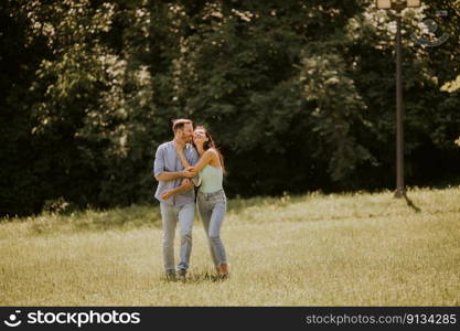 Happy young couple in love at the grass field on a summer day