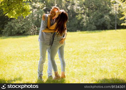 Happy young couple in love at the grass field on a summer day