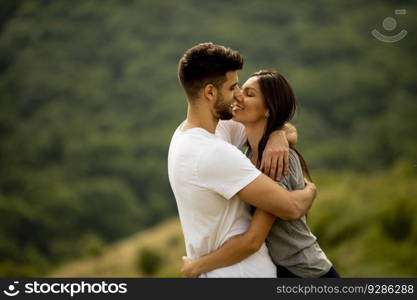 Happy young couple in love at the grass field on a summer day