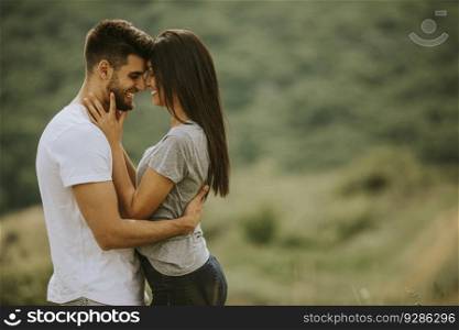 Happy young couple in love at the grass field on a summer day