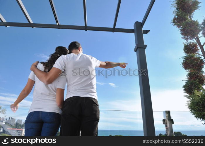 happy young couple in love have romance relax on balcony outdoor with ocean and blue sky in background