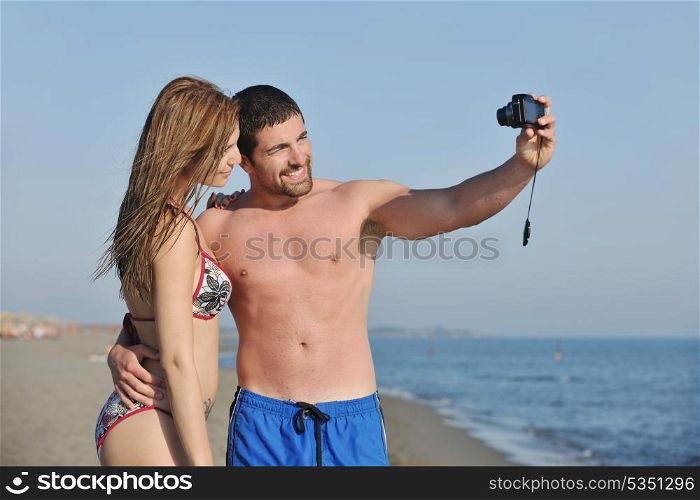 happy young couple in love taking amateur self portrait photos on beach