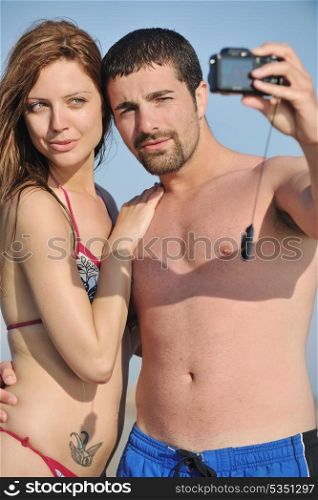happy young couple in love taking amateur self portrait photos on beach