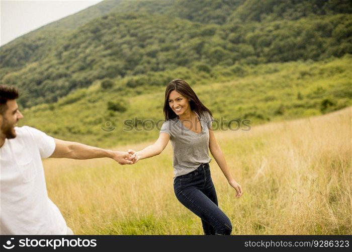 Happy young couple in love walking through grass field