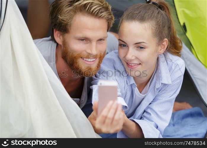 happy young couple in tent during camping