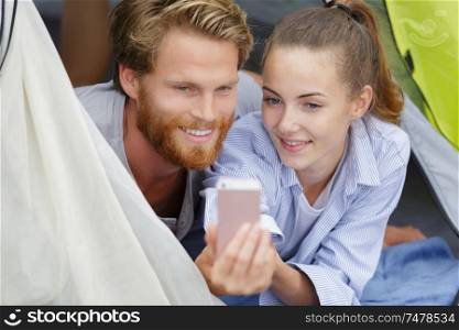 happy young couple in tent during camping
