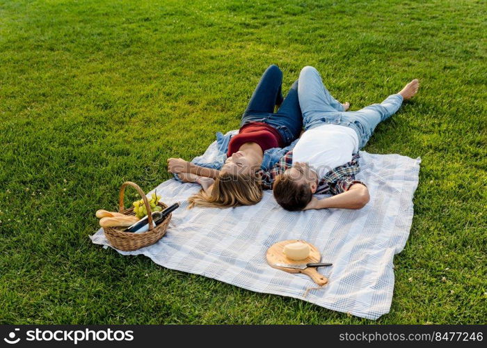 Happy young couple in the park relaxing after the picnic