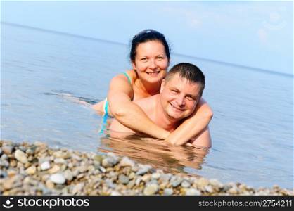 Happy young couple in the sea. Lie in water