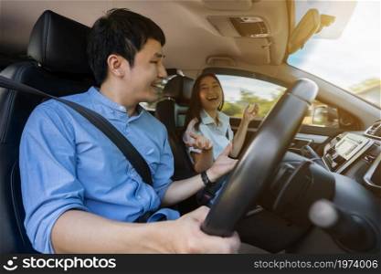 happy young couple is talking while driving a car