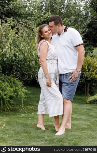 happy young couple kissing and hugging outdoors on summer day. woman and man in love in the park .. happy young couple kissing and hugging outdoors on summer day. woman and man in love in the park