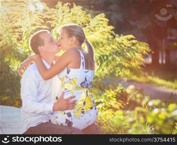 Happy young couple kissing outdoor in the park