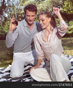 happy young couple listening to MP3 player in square
