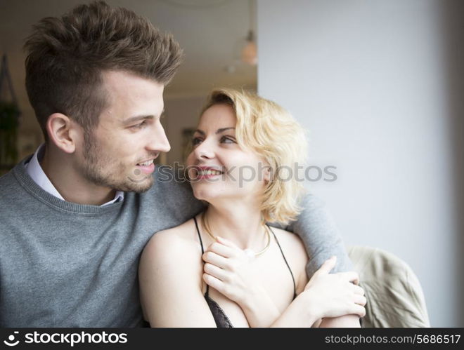 Happy young couple looking at each other in cafe