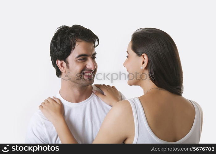 Happy young couple looking at each other over white background