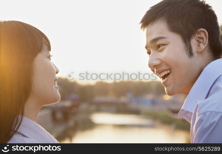 Happy Young Couple Looking at the Camera by a River