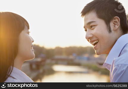 Happy Young Couple Looking at the Camera by a River