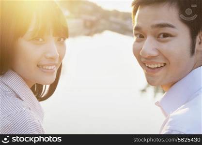 Happy Young Couple Looking at the Camera by a River