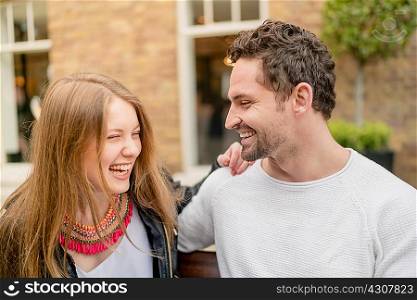 Happy young couple on park bench