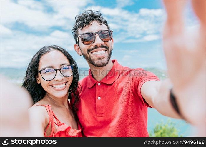 Happy Young couple on vacation taking a selfie near the beach. Smiling young couple taking a self portrait in the bay of San Juan del Sur