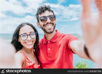 Happy Young couple on vacation taking a selfie near the beach. Smiling young couple taking a self portrait in the bay of San Juan del Sur