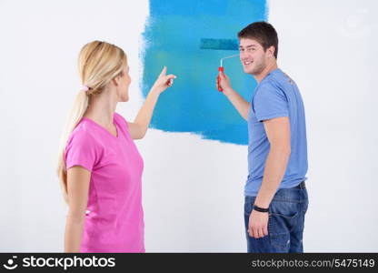 happy young couple paint in green and blue color white wall of their new home