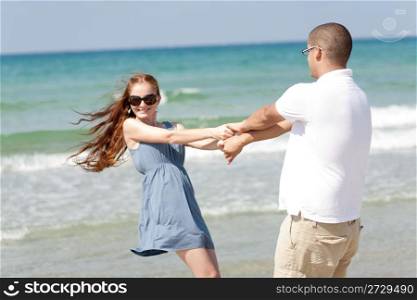 happy young couple play at beach