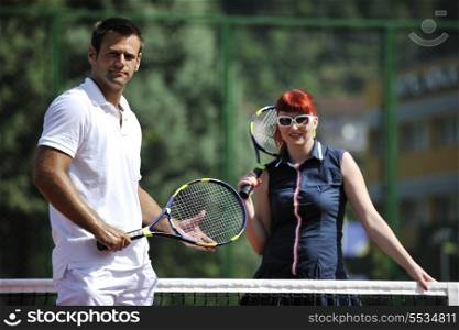 happy young couple play tennis game outdoor man and woman