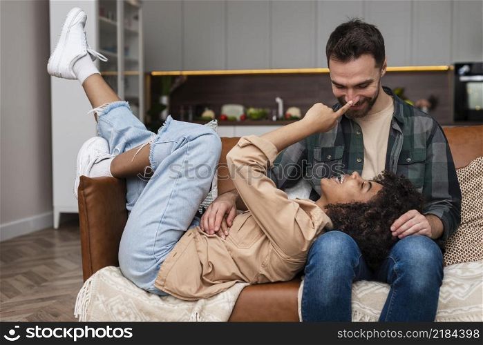 happy young couple playing sofa