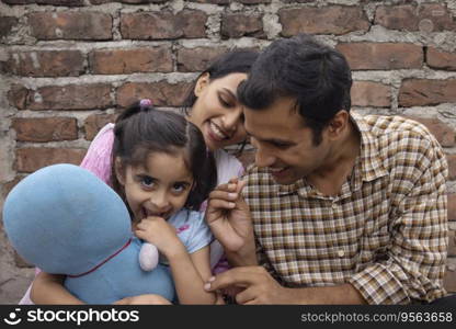 Happy young couple playing with their daughter in backyard