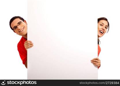 Happy young couple pointing at bill board