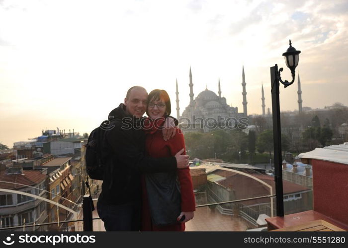 happy young couple portrait outdoor at sunny day in istanbul turkey with beautiful old mosque with sunset in background