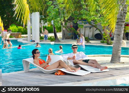 happy young couple relax and take fresh drink at summer vacation on swimmin pool