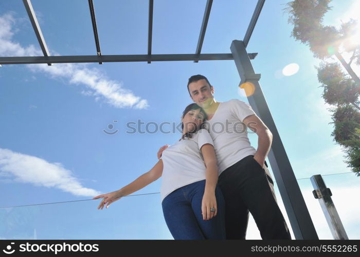 happy young couple relax on balcony outdoor with ocean and blue sky in background