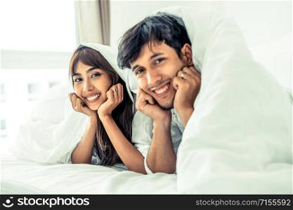 Happy young couple relaxing at home in the morning.. Happy young couple relaxing in the home bedroom.