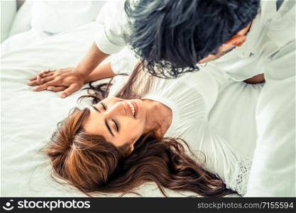 Happy young couple relaxing at home in the morning.. Romantic love of young couple in the bedroom.