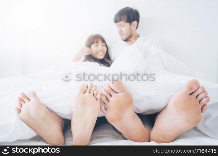 Happy young couple relaxing in home bedroom after waking up in the morning.. Happy young couple relaxing in the home bedroom.