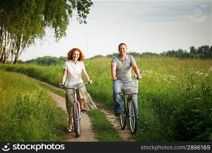 Happy young couple riding on a bicycles