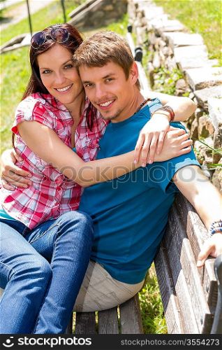 Happy young couple sitting bench in park love people portrait