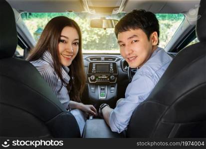 happy young couple sitting in a car